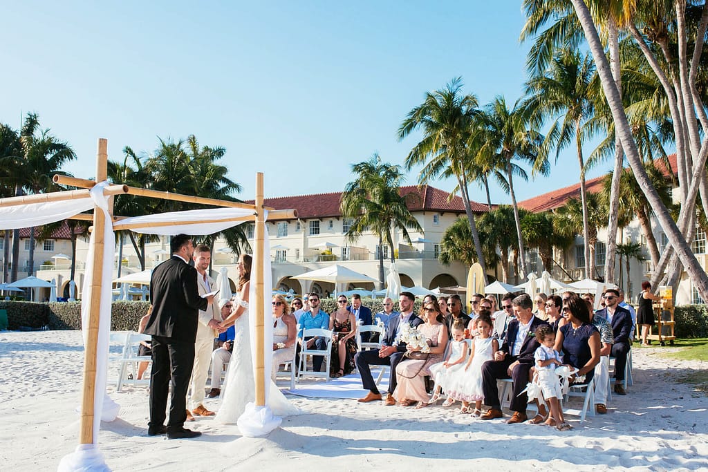 A couple says their wedding vows with Casa Marina in the backdrop.
