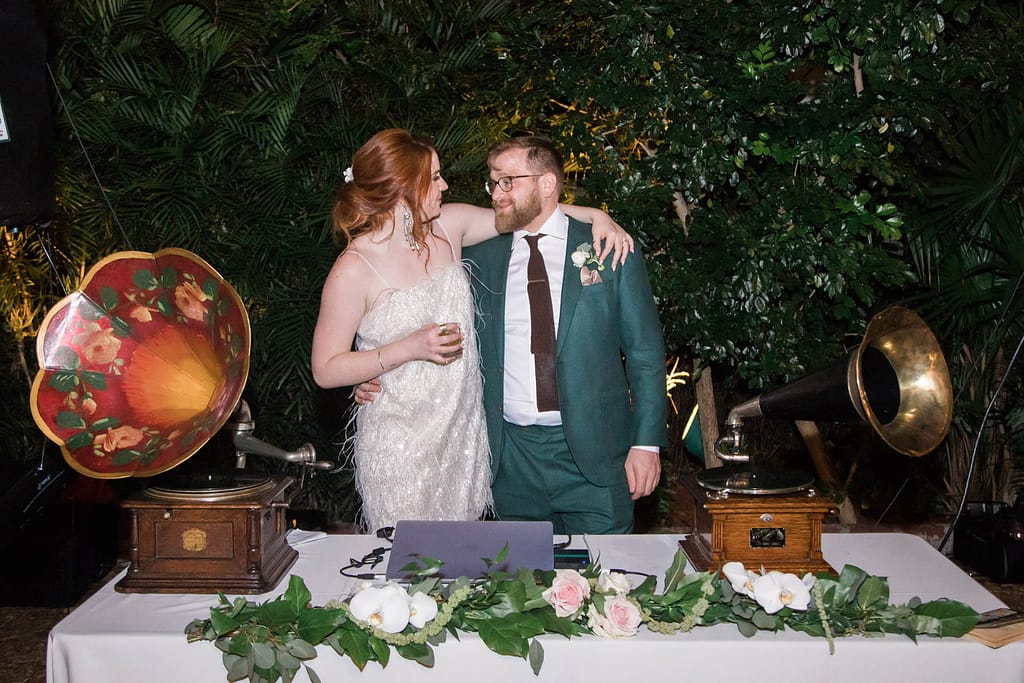 A couple poses by their retro dj setup.