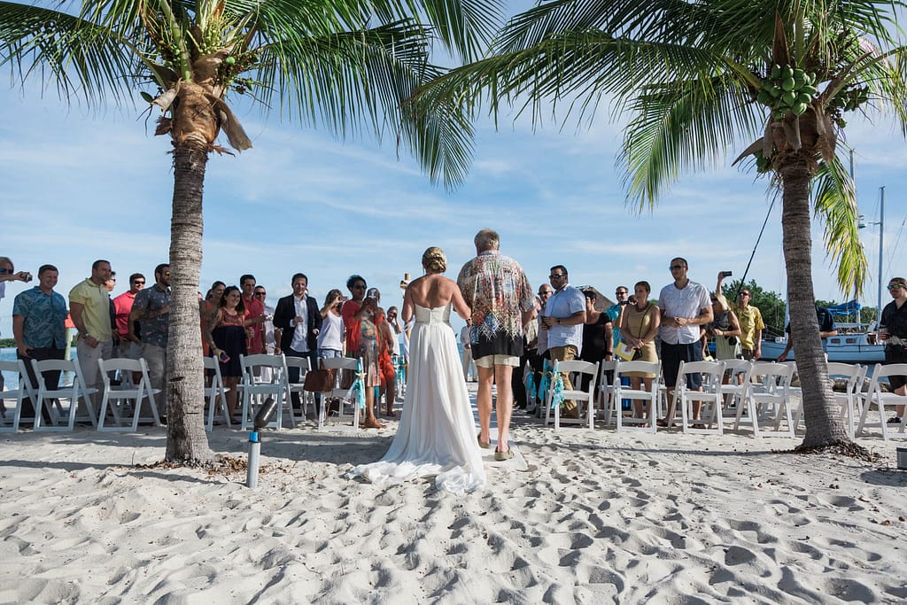 A bride walks down the aisle with her father.