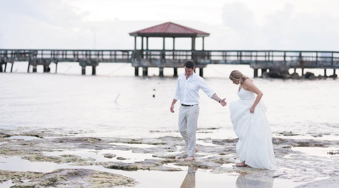 A couple walks on the beach after their wedding. If you are looking to hire vendors from afar, it can feel super stressful but it doesn't have to.