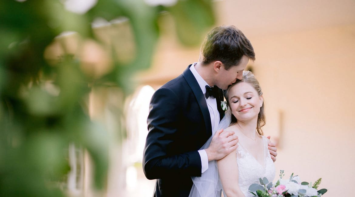 A couple kisses during their first look at the Casa Marina