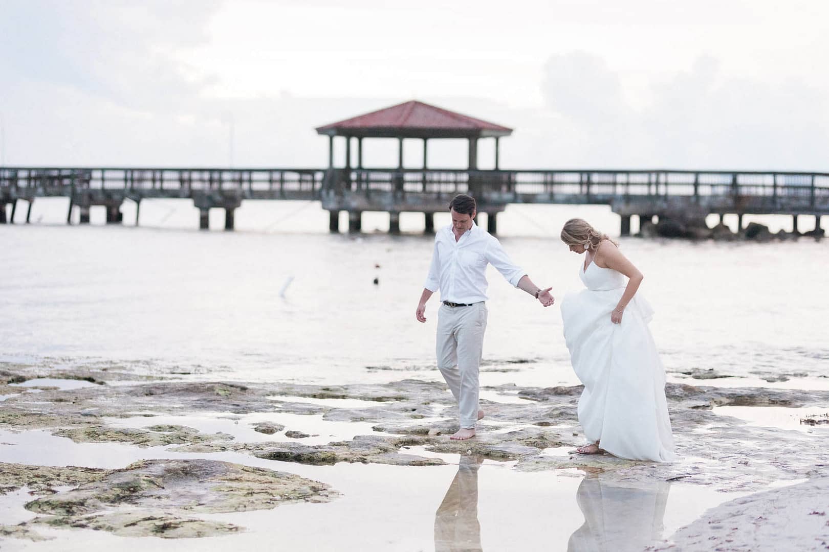 A couple walks on the beach after their wedding. If you are looking to hire vendors from afar, it can feel super stressful but it doesn't have to.