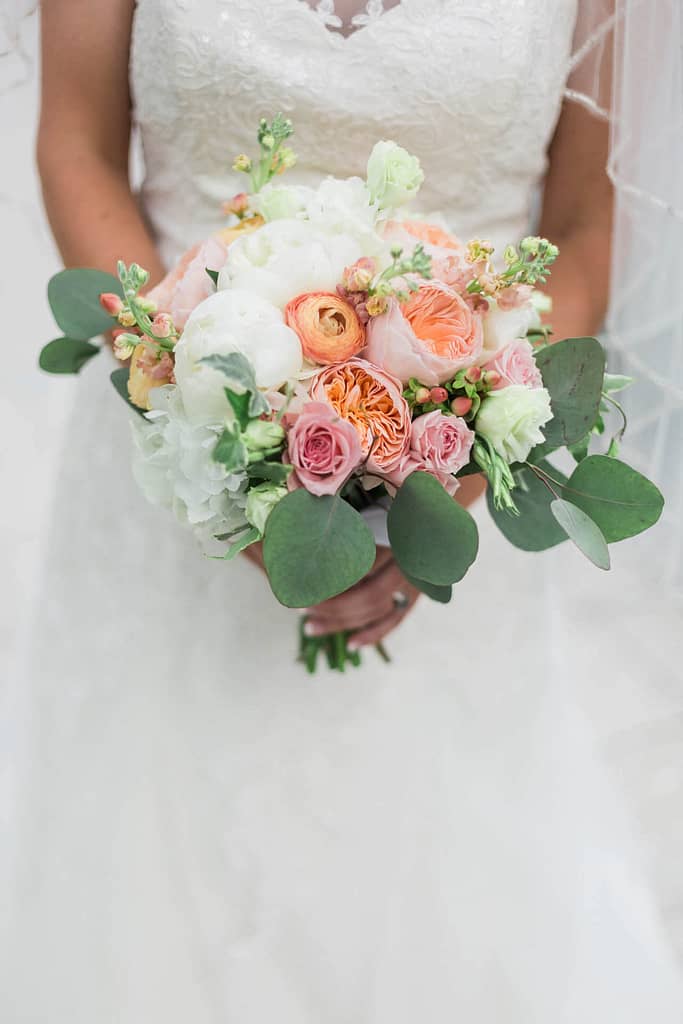 A bride holds her wedding flowers as she walks down the aisle.