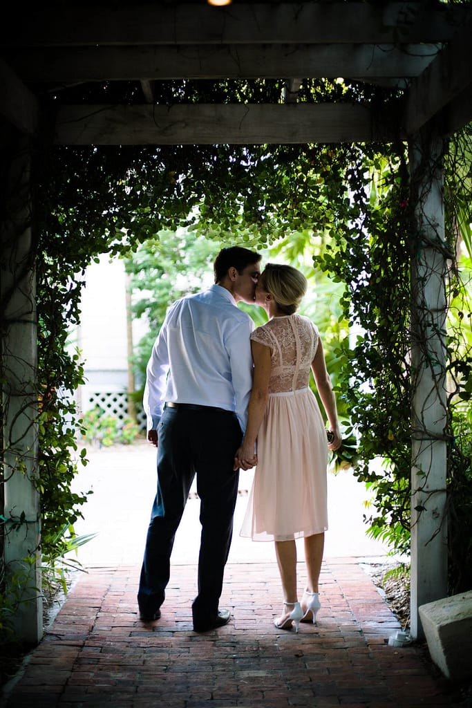 A couple kisses in the gardens off of Duval Street.