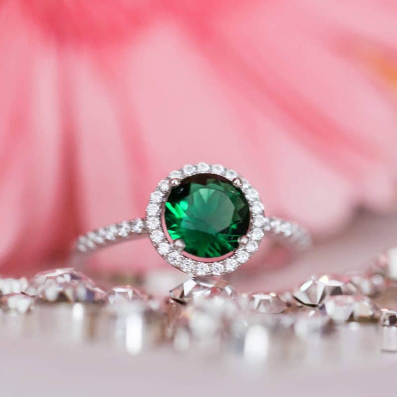 an emerald with tropical florals in the background.